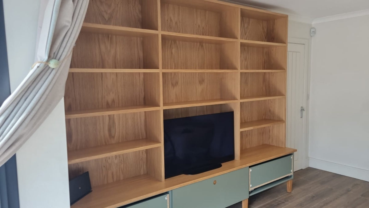 Completed oak-effect fitted media wall with storage