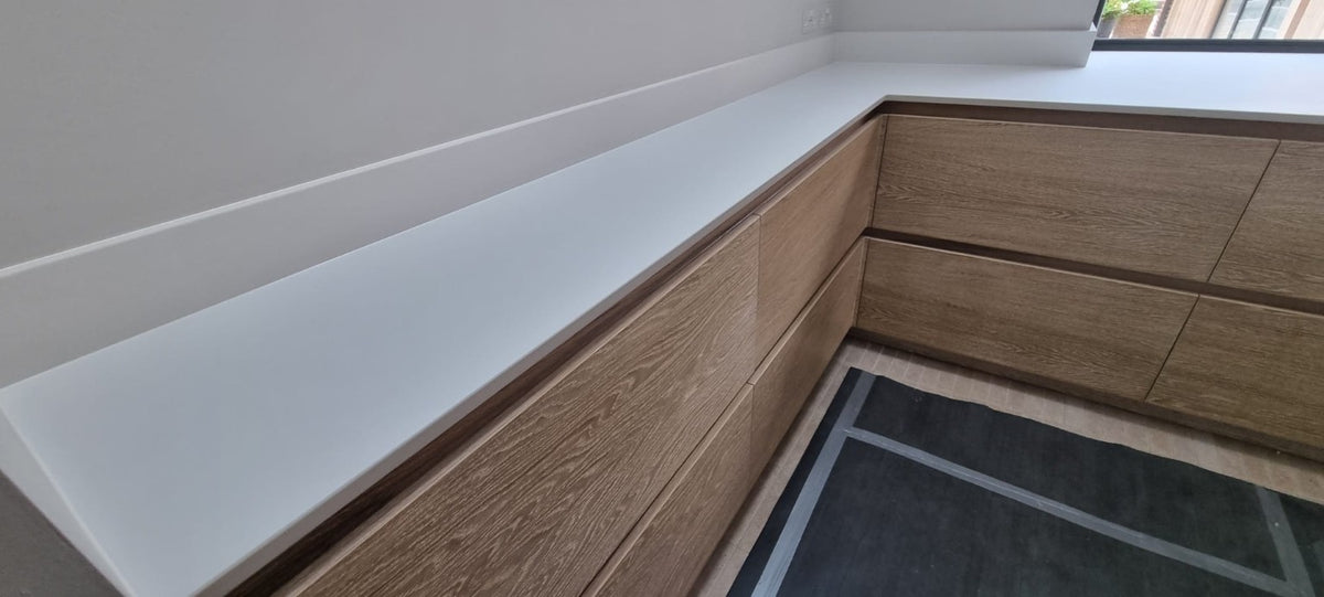 Oak-effect handleless kitchen drawers and white worktop